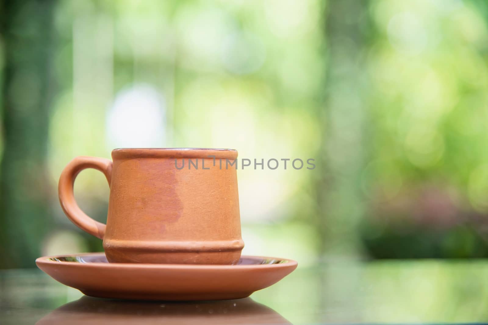 Coffee cup in green garden background - coffee with nature background concept by pairhandmade