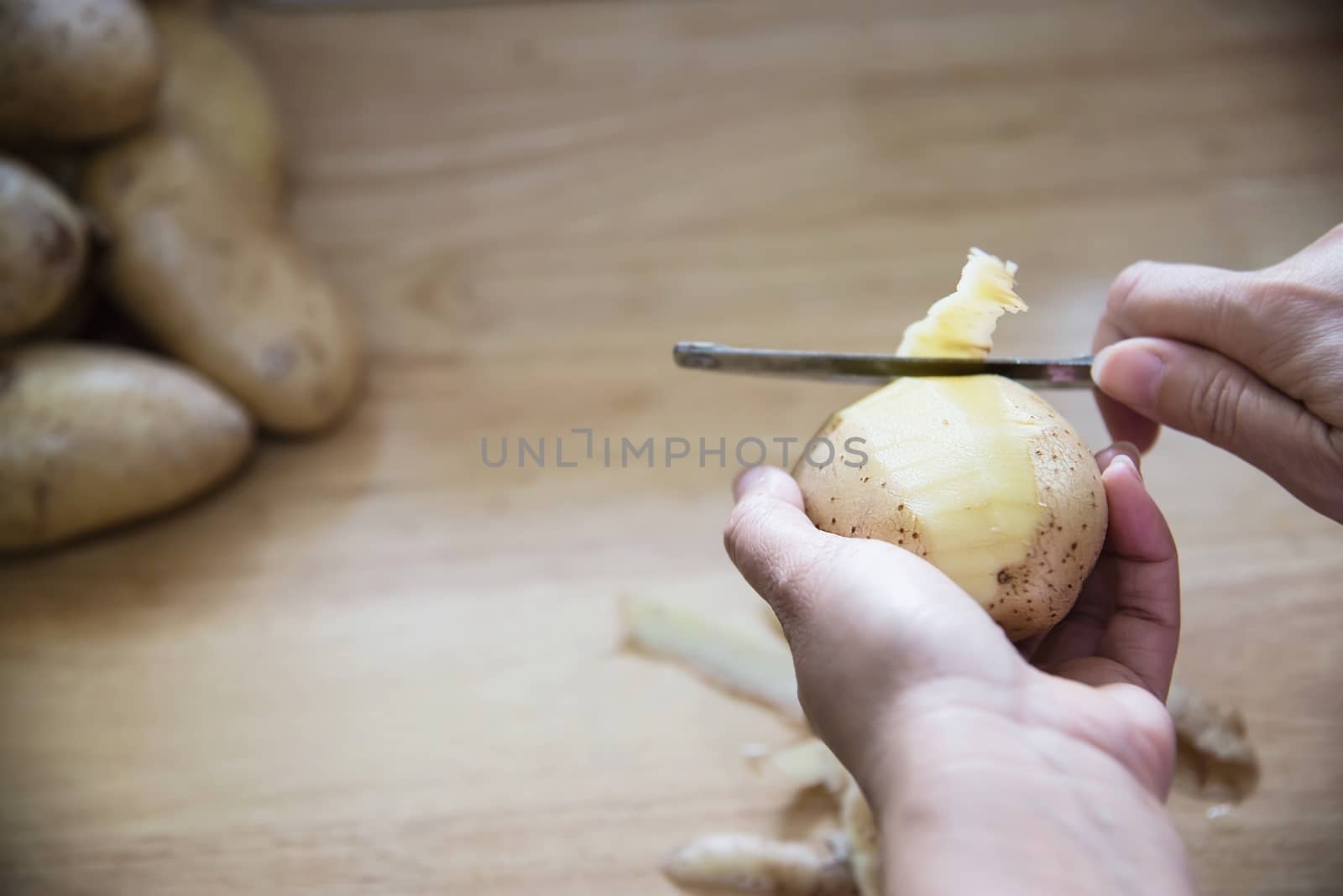 People cooking fresh potato preparing food in the kitchen - potato cooking concept