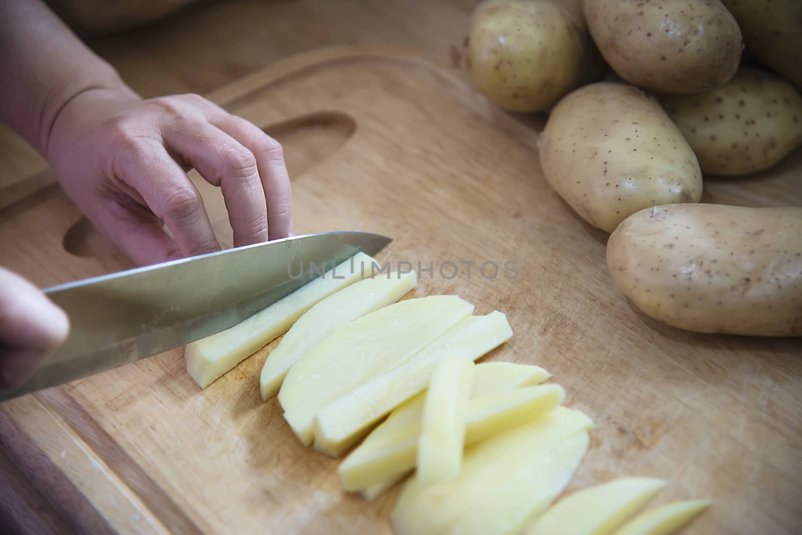 People cooking fresh potato preparing food in the kitchen - potato cooking concept