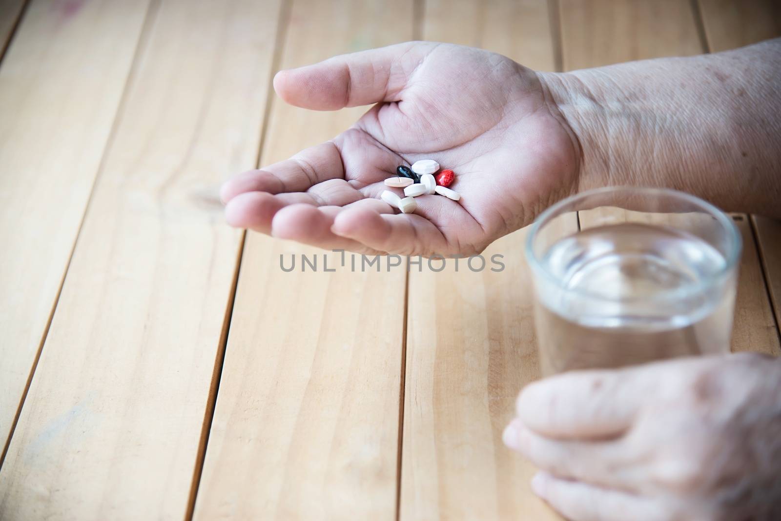 Old lady prepare to eat daily medicine pill - people healthcare with medicine pills concept by pairhandmade