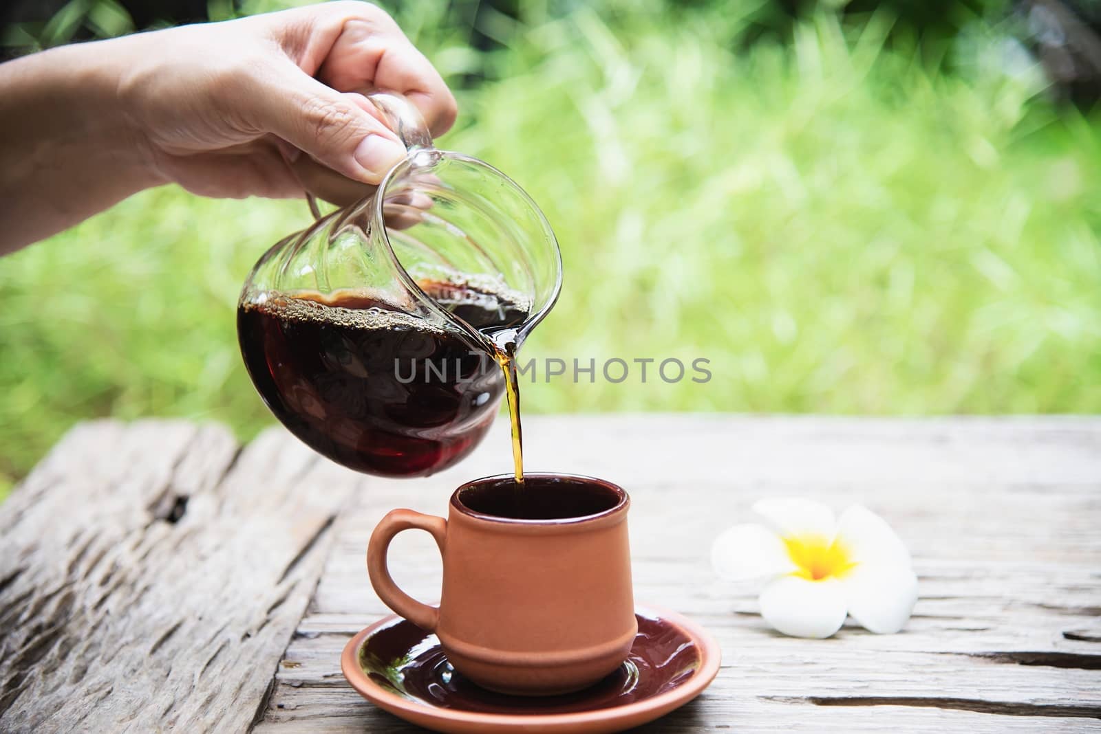Man making drip fresh coffee in vintage coffee shop with green nature background - people with fresh coffee in nature concept by pairhandmade