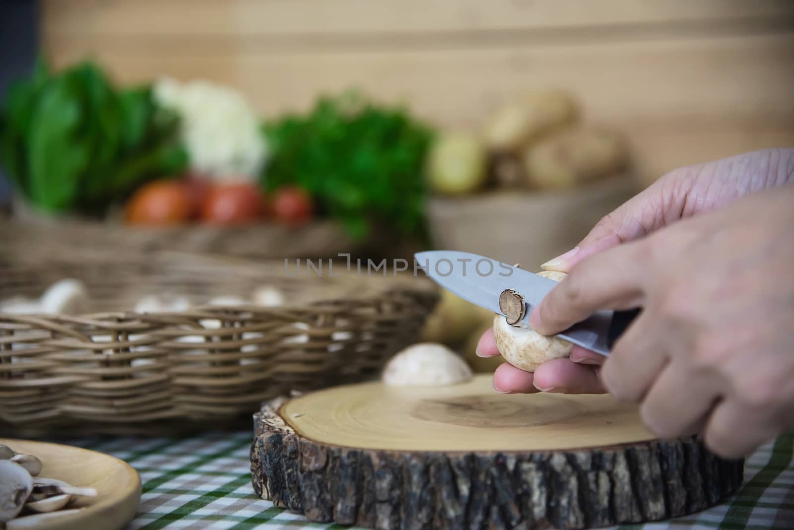Lady cooks fresh champignon mushroom vegetable in the kitchen - people with vegetable cooking concept by pairhandmade