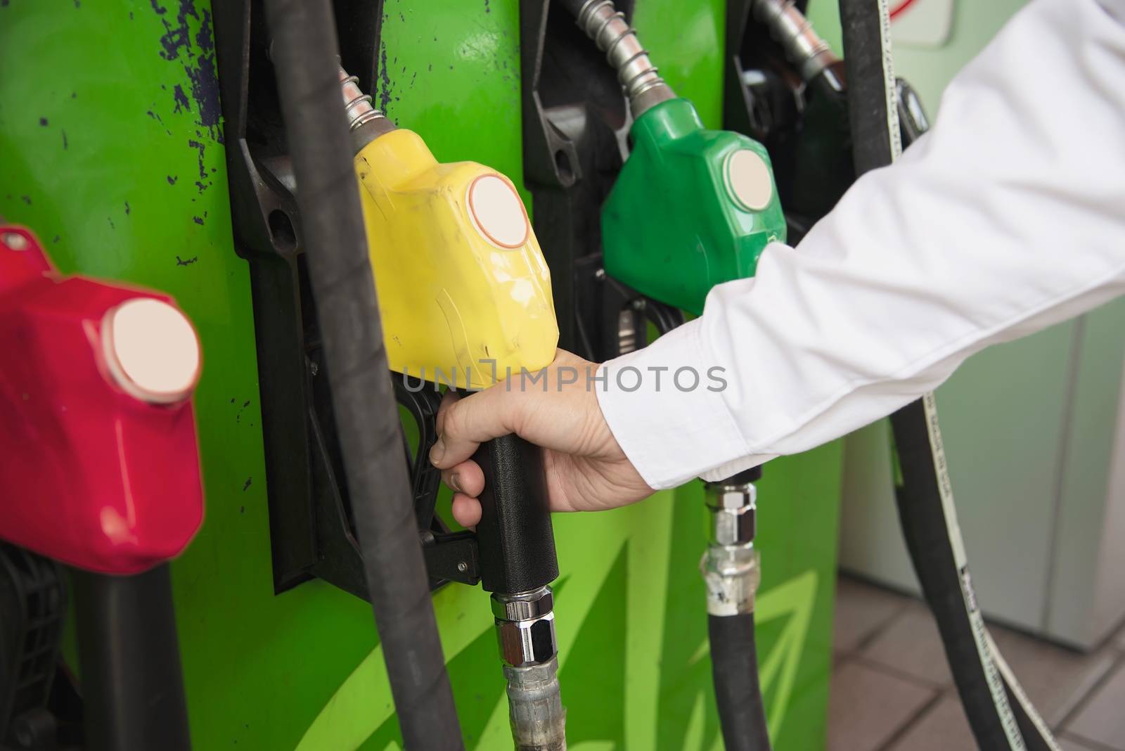 Man putting gasoline fuel into his car in a pump gas station