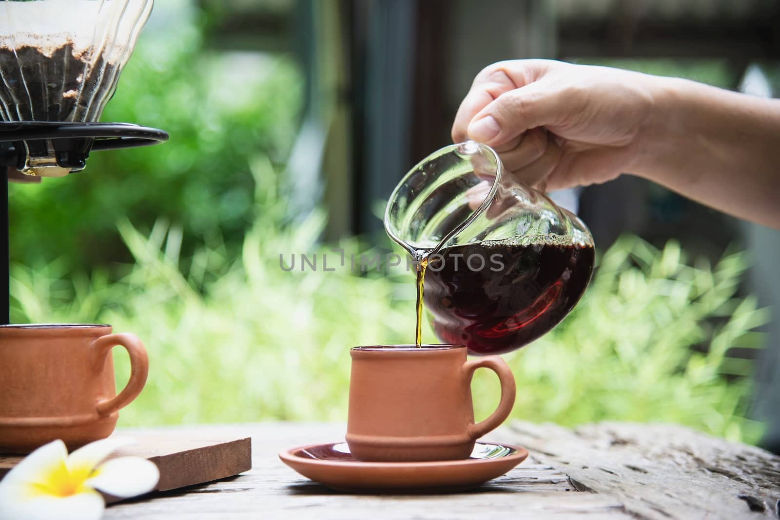 Man making drip fresh coffee in vintage coffee shop with green nature background - people with fresh coffee in nature concept