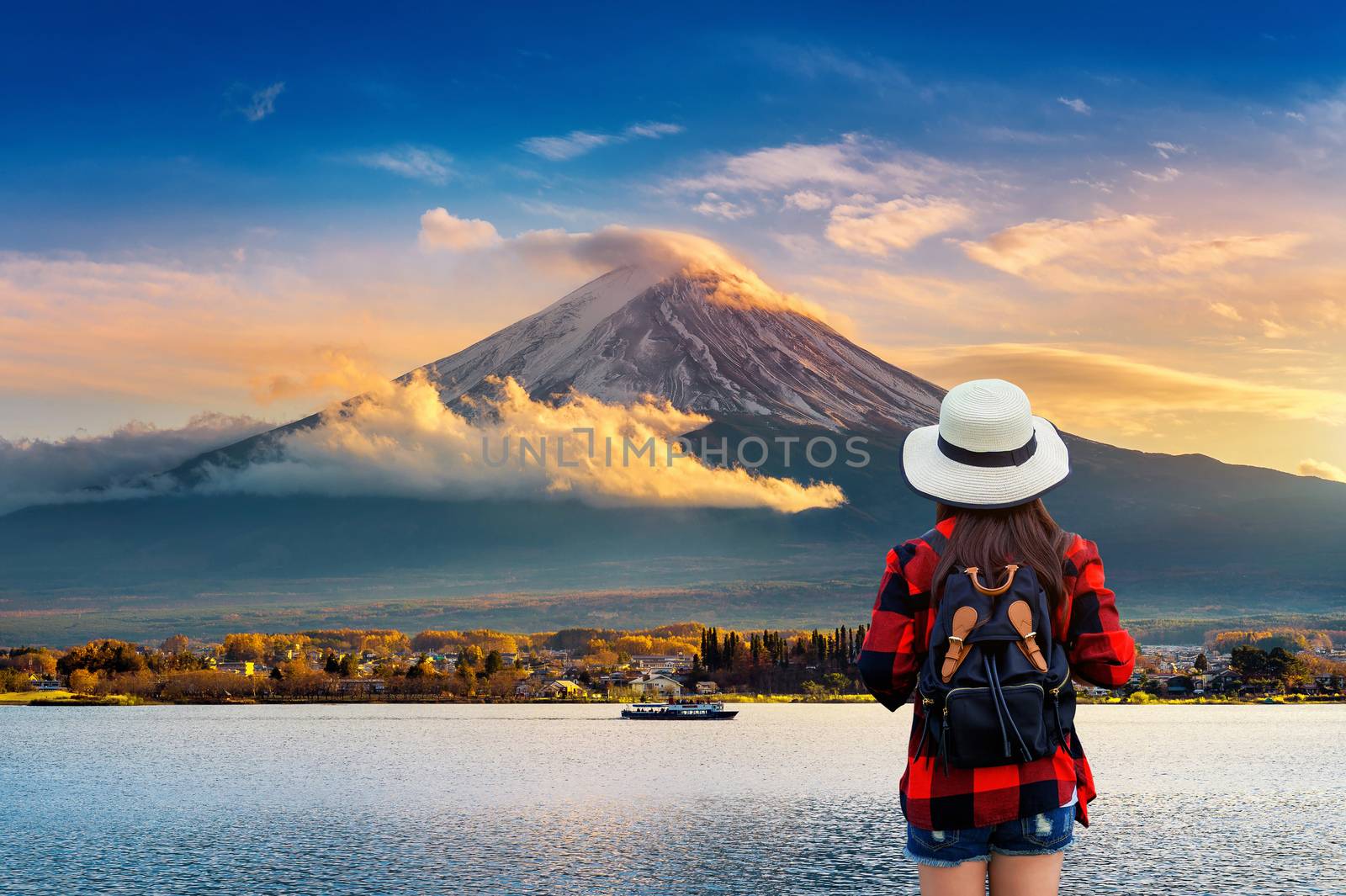 Woman traveler with backpack looking to Fuji mountains at sunset by gutarphotoghaphy