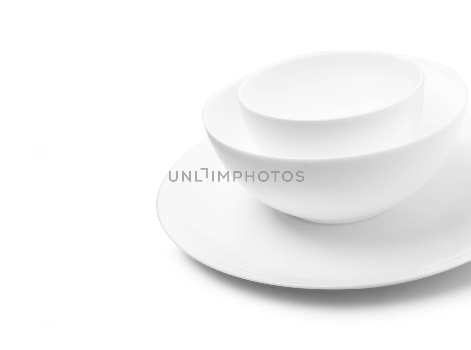 Set of white dishes on table on light background. With clippig path