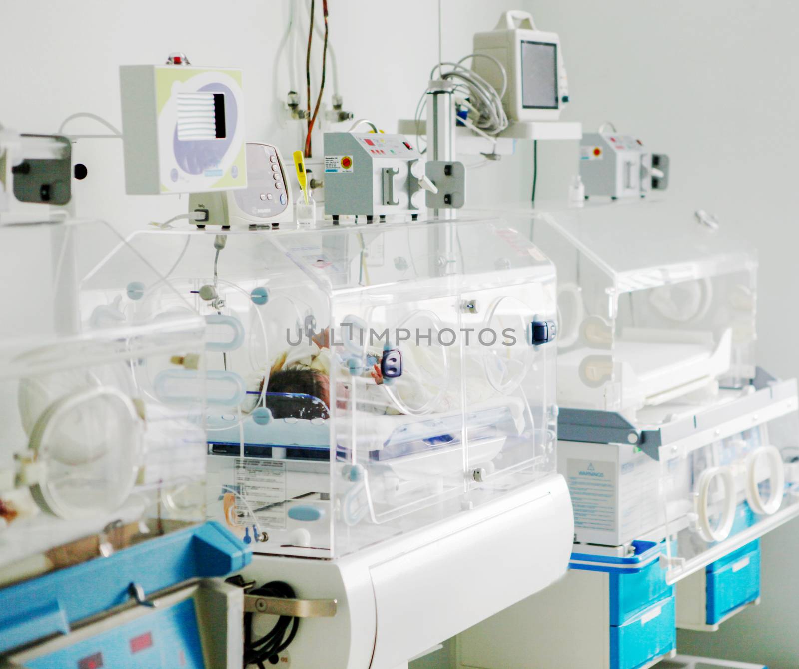 Newborn baby in hospital incubator.