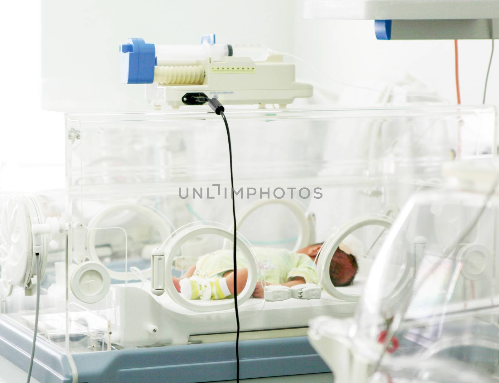 Newborn baby in hospital incubator.