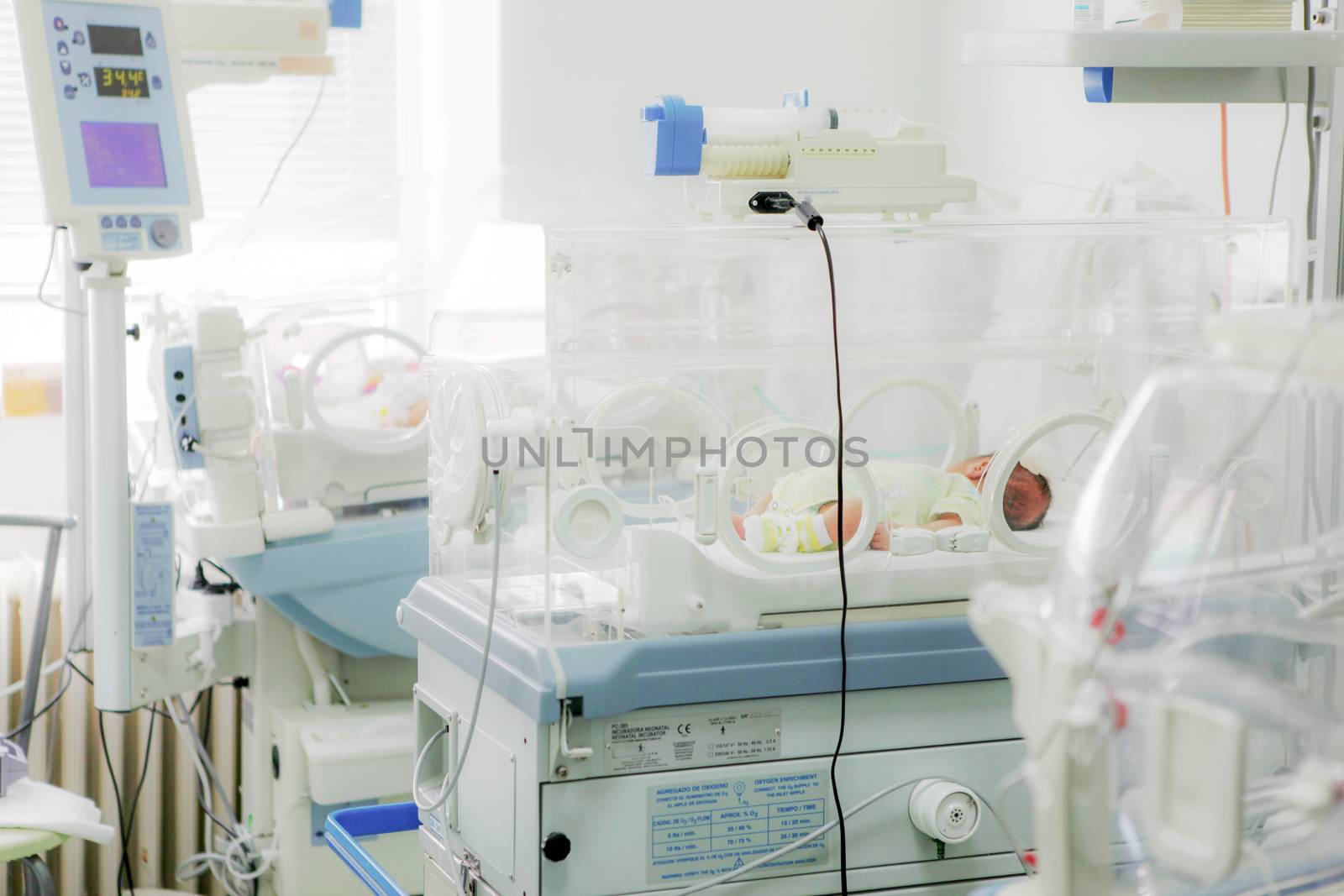 Newborn baby in hospital incubator.