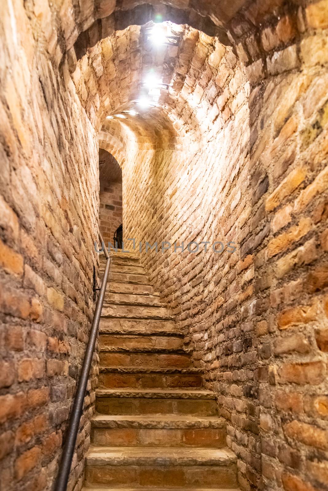 Narrow staircase in old cellar with brick walls by pyty