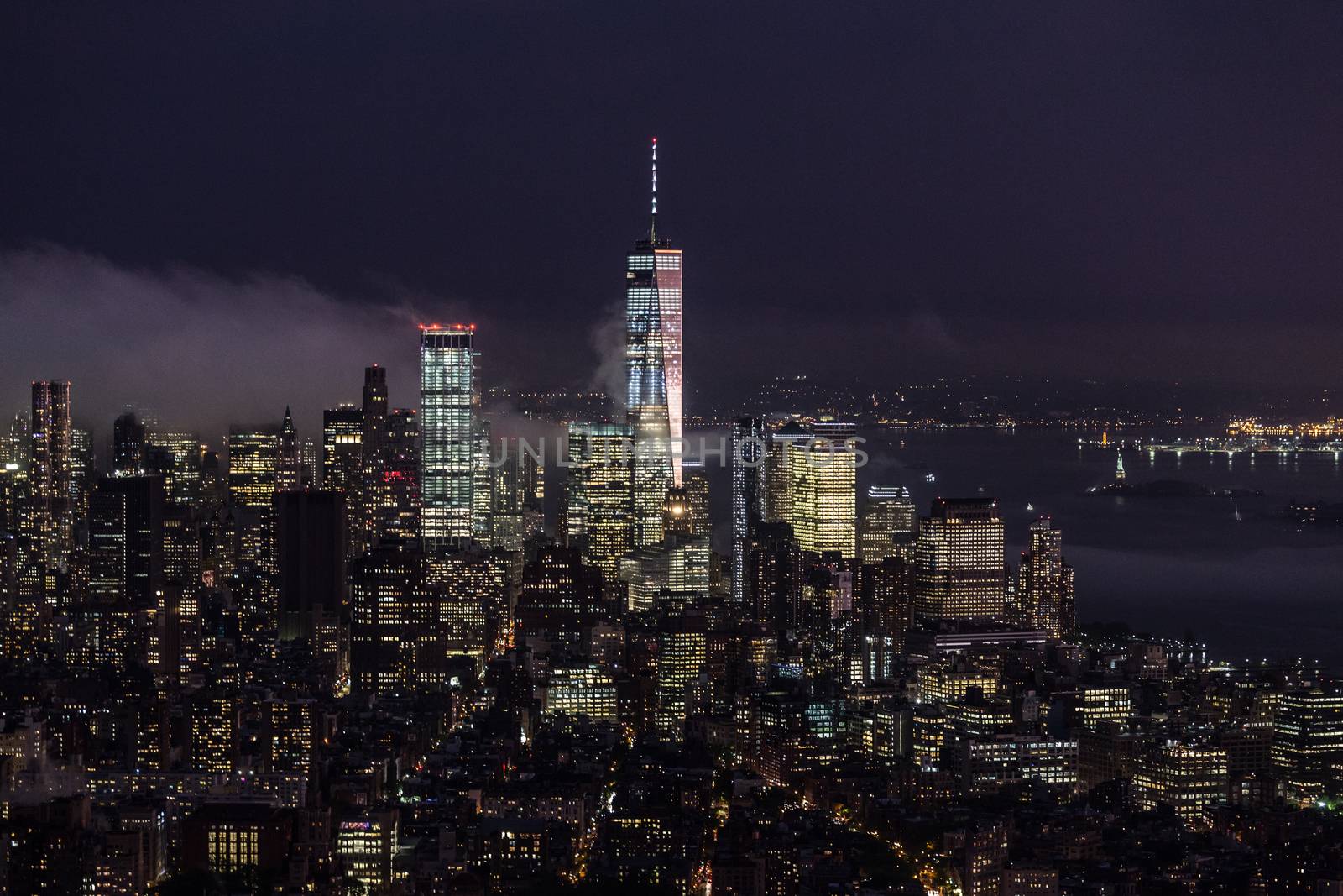 New York City skyline with lower Manhattan skyscrapers in storm at night.