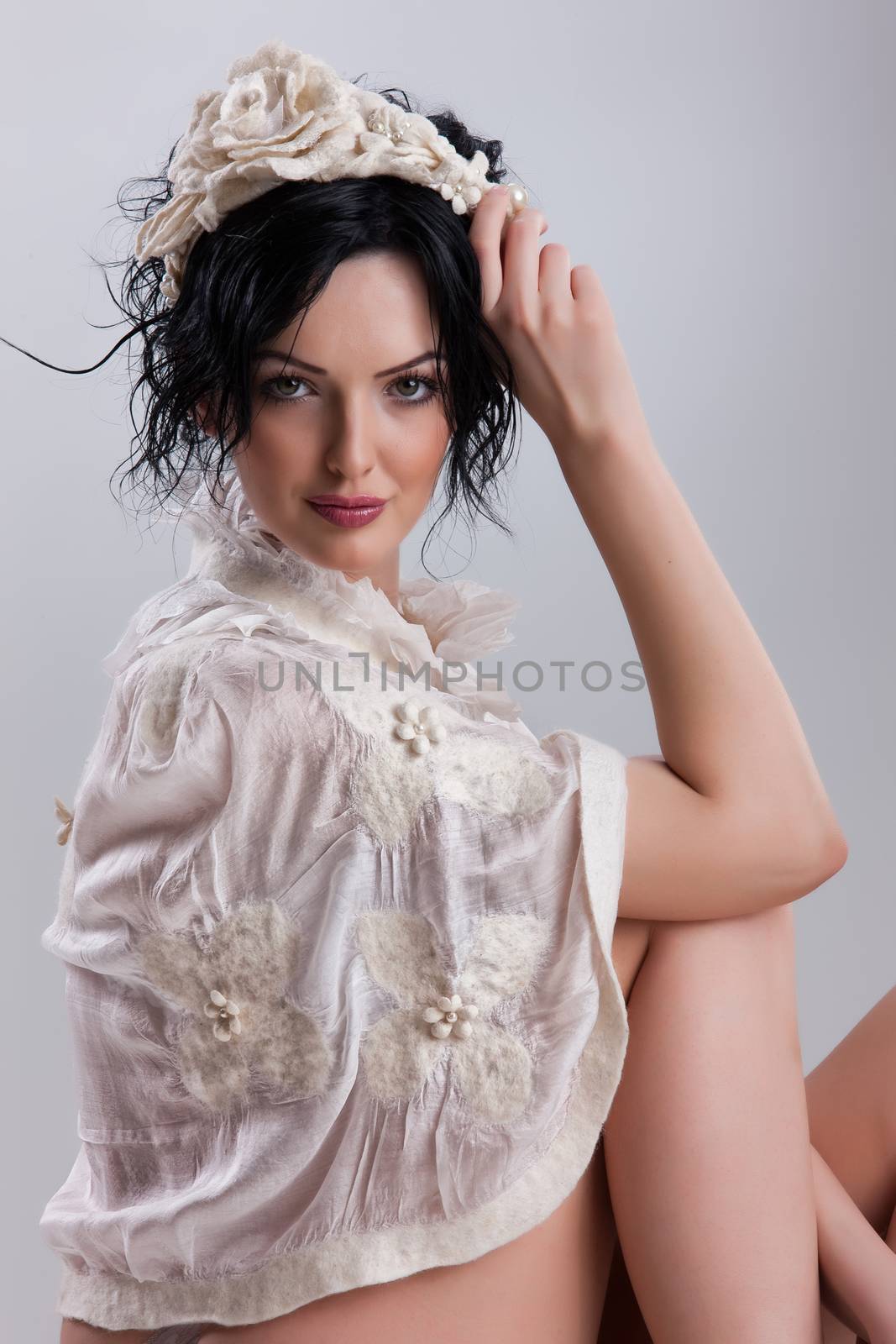 Young attractive woman dressed in handmade clothing on isolated background