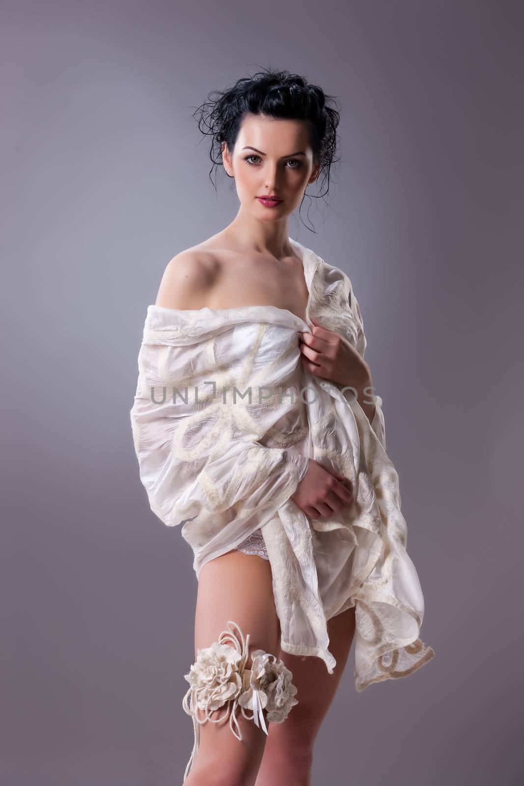 Young attractive woman dressed in handmade clothing on isolated background