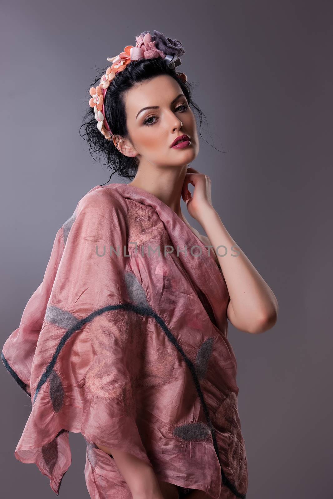 Young attractive woman dressed in handmade clothing on isolated background