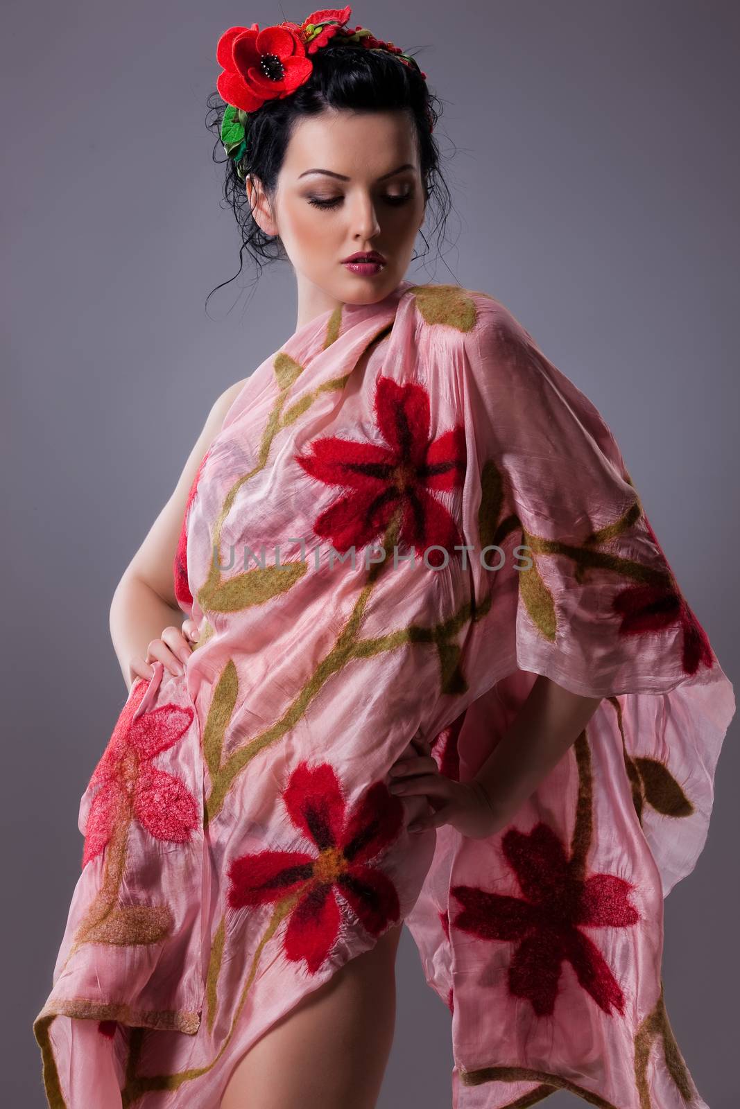Young attractive woman dressed in handmade clothing on isolated background