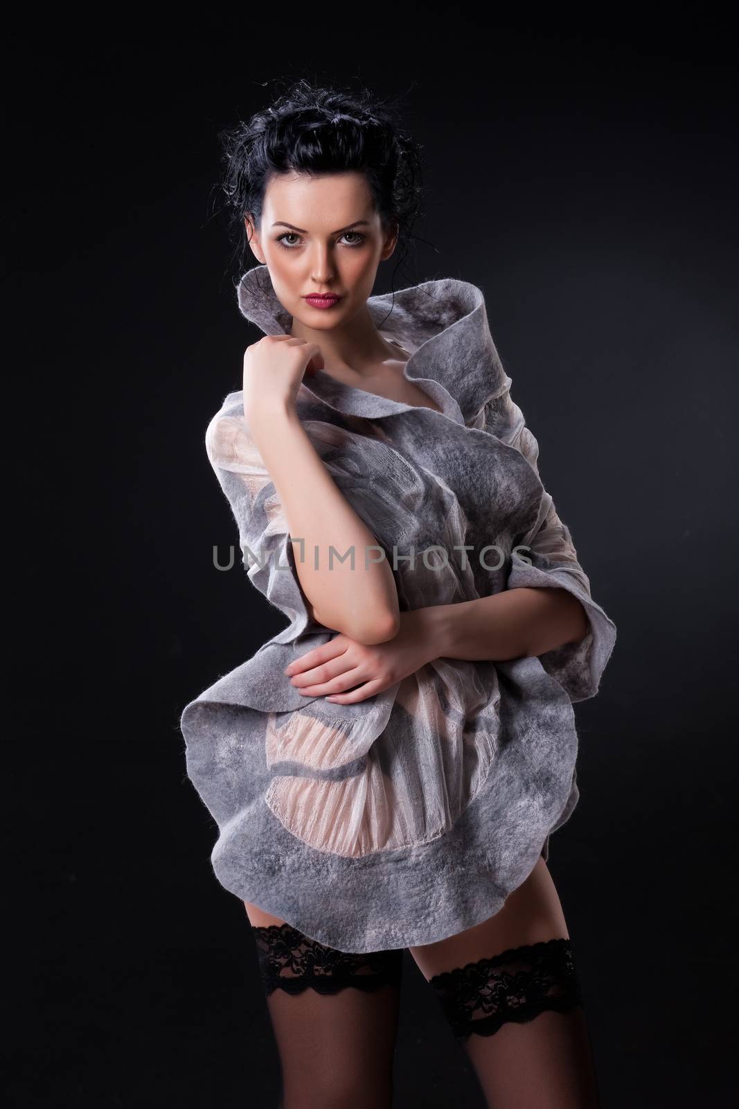 Young attractive woman dressed in handmade clothing on isolated background
