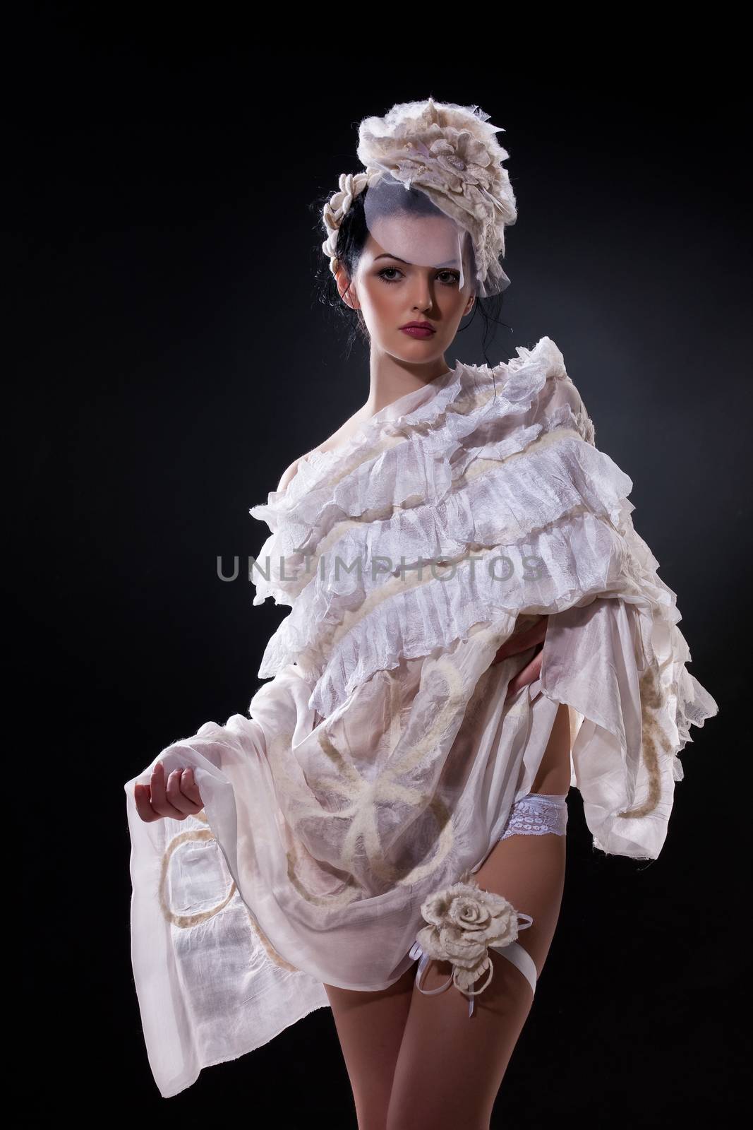 Young attractive woman dressed in handmade clothing on isolated background