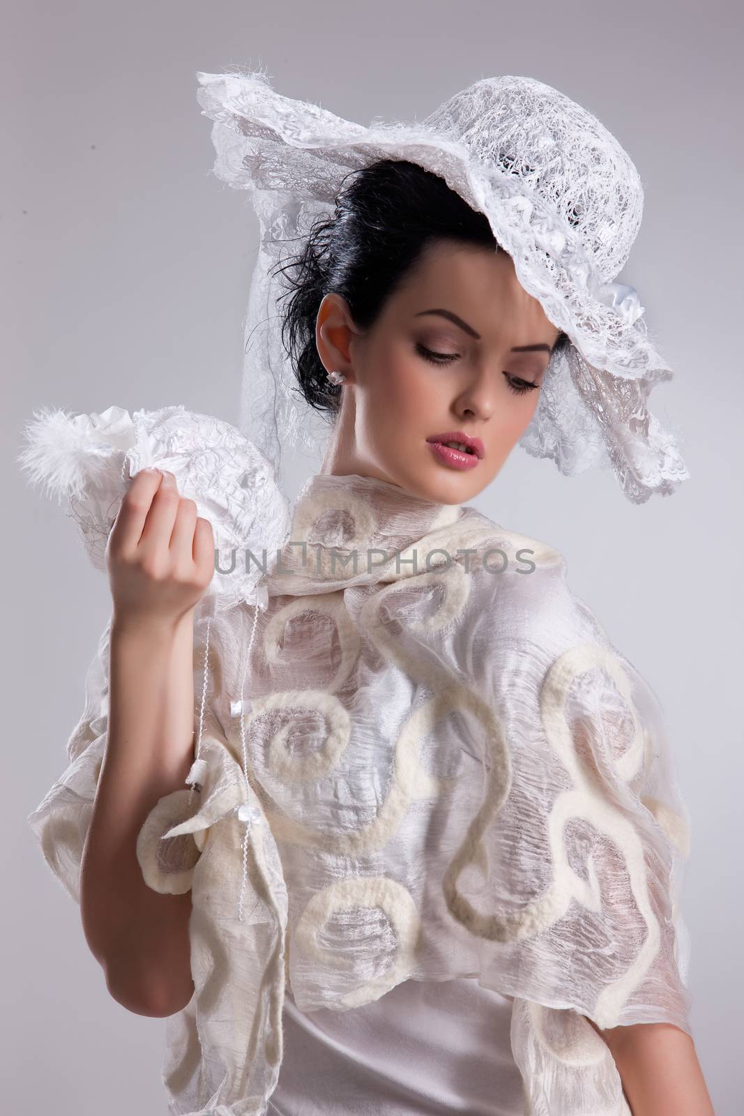 Young attractive woman dressed in handmade clothing on isolated background