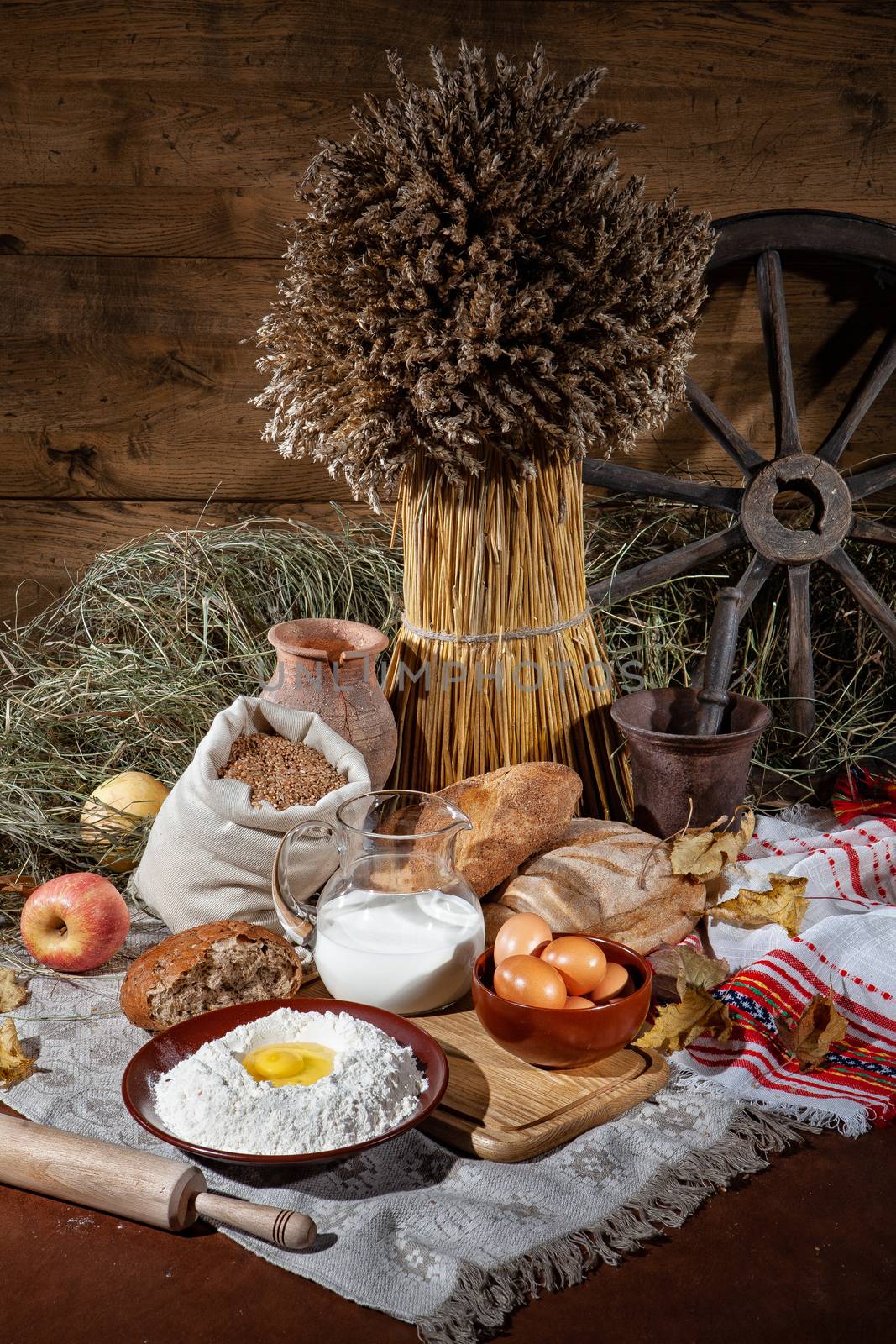 Different kinds of bread and rural accessories on a fabric background