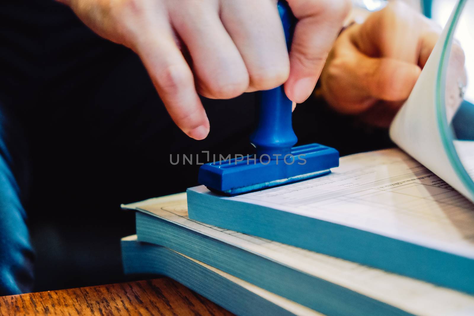 Close-up hand stamping rubber Stamp on a documents, business concept