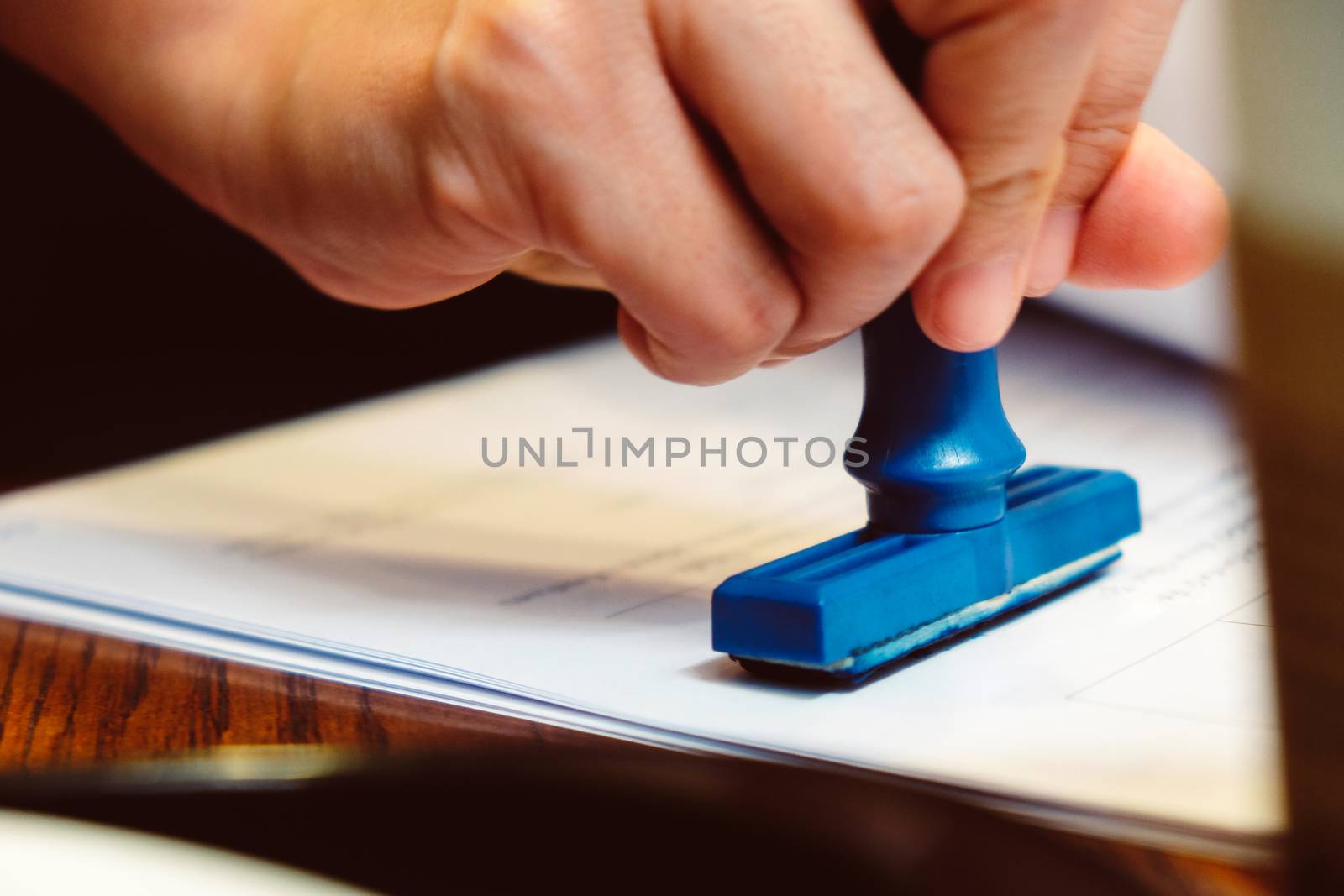 Close-up hand stamping rubber Stamp on a documents, business concept