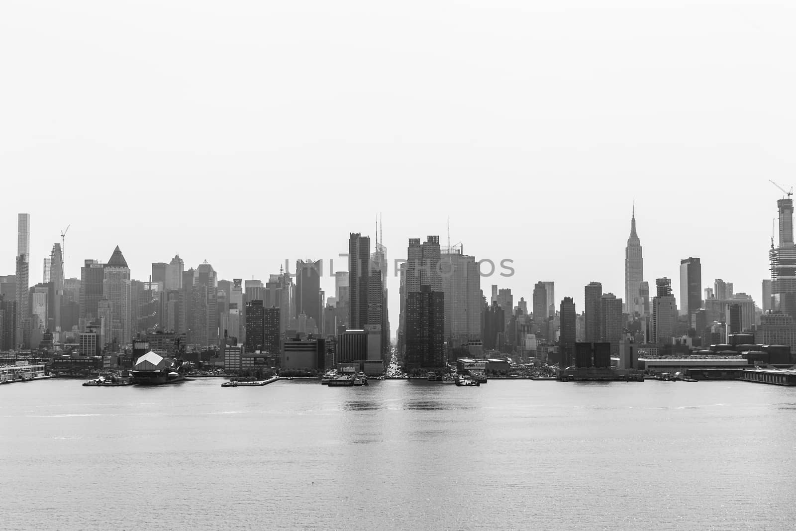 New York City midtown Manhattan skyline panorama view from Boulevard East Old Glory Park over Hudson River on a misty morning. Black and white image.