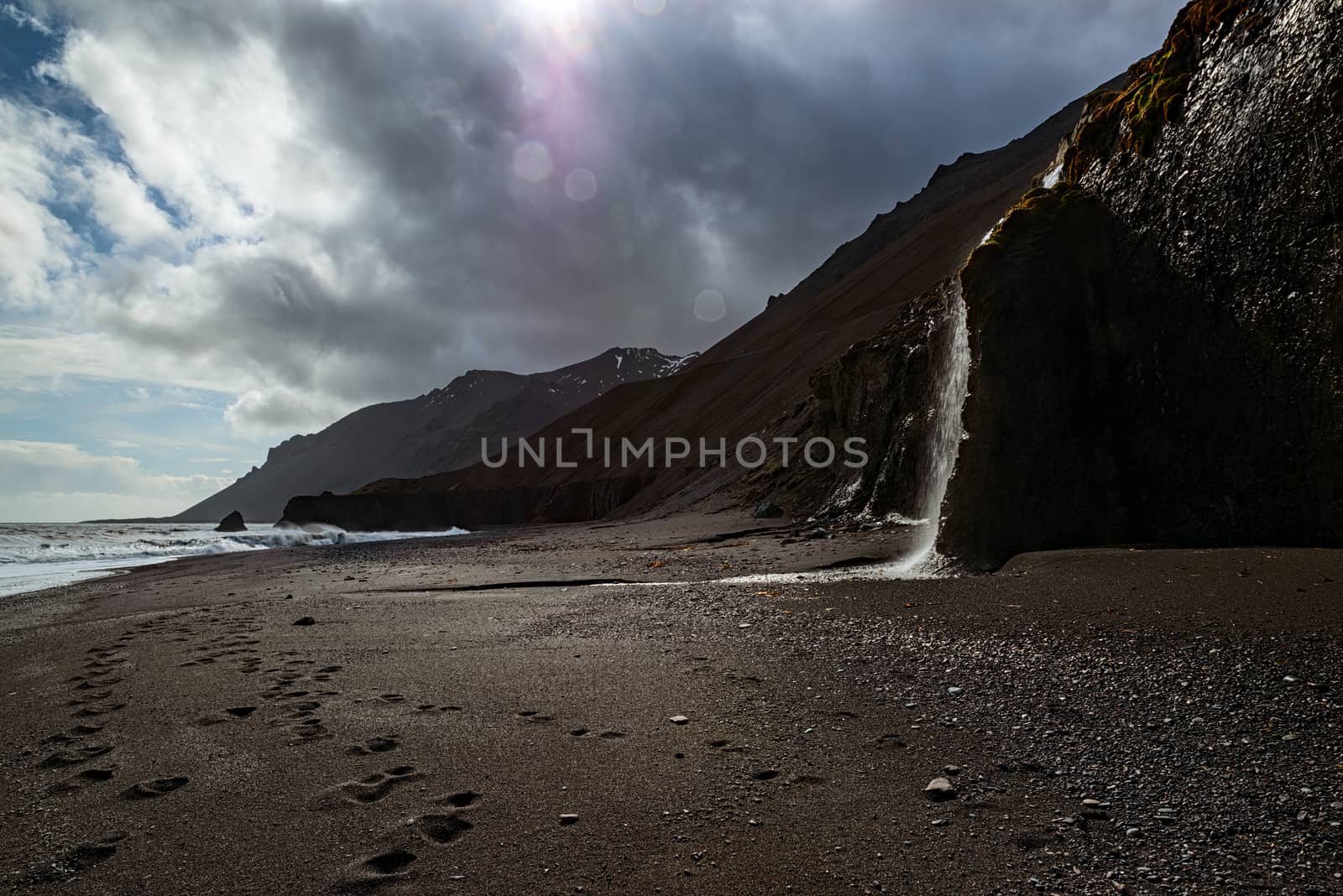 Waterfall in a black beach in Laekjavik bay, Iceland