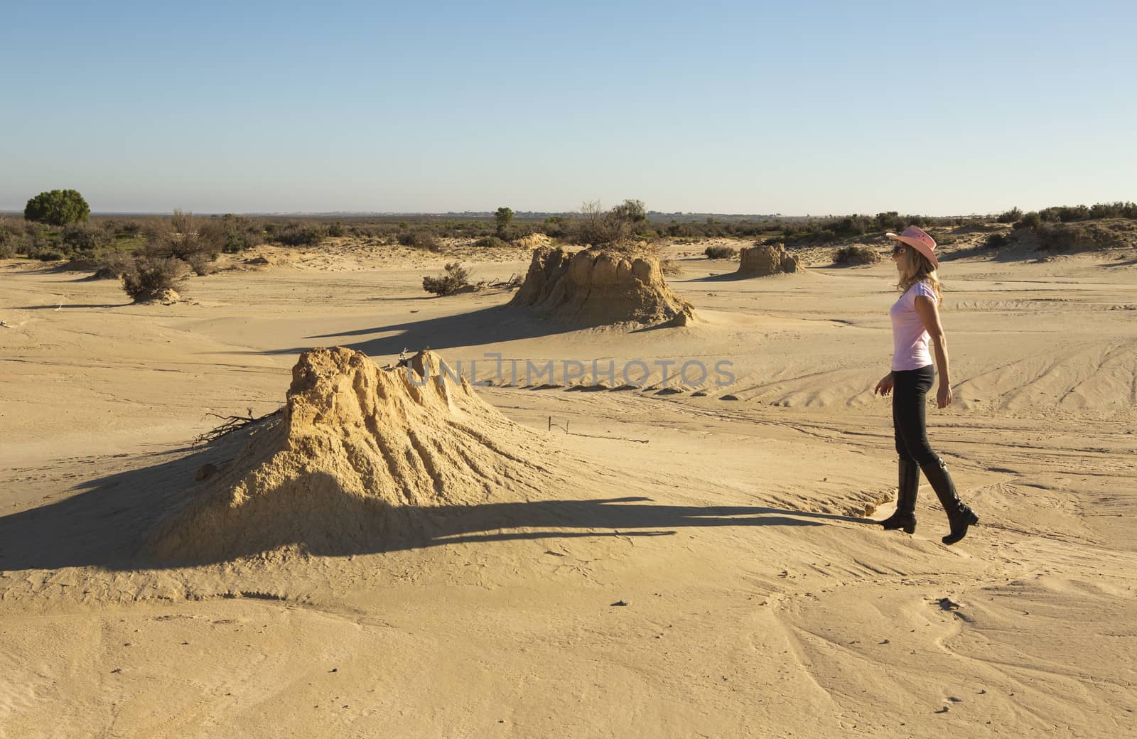 A woman walks in a desert landscape of outback Australia