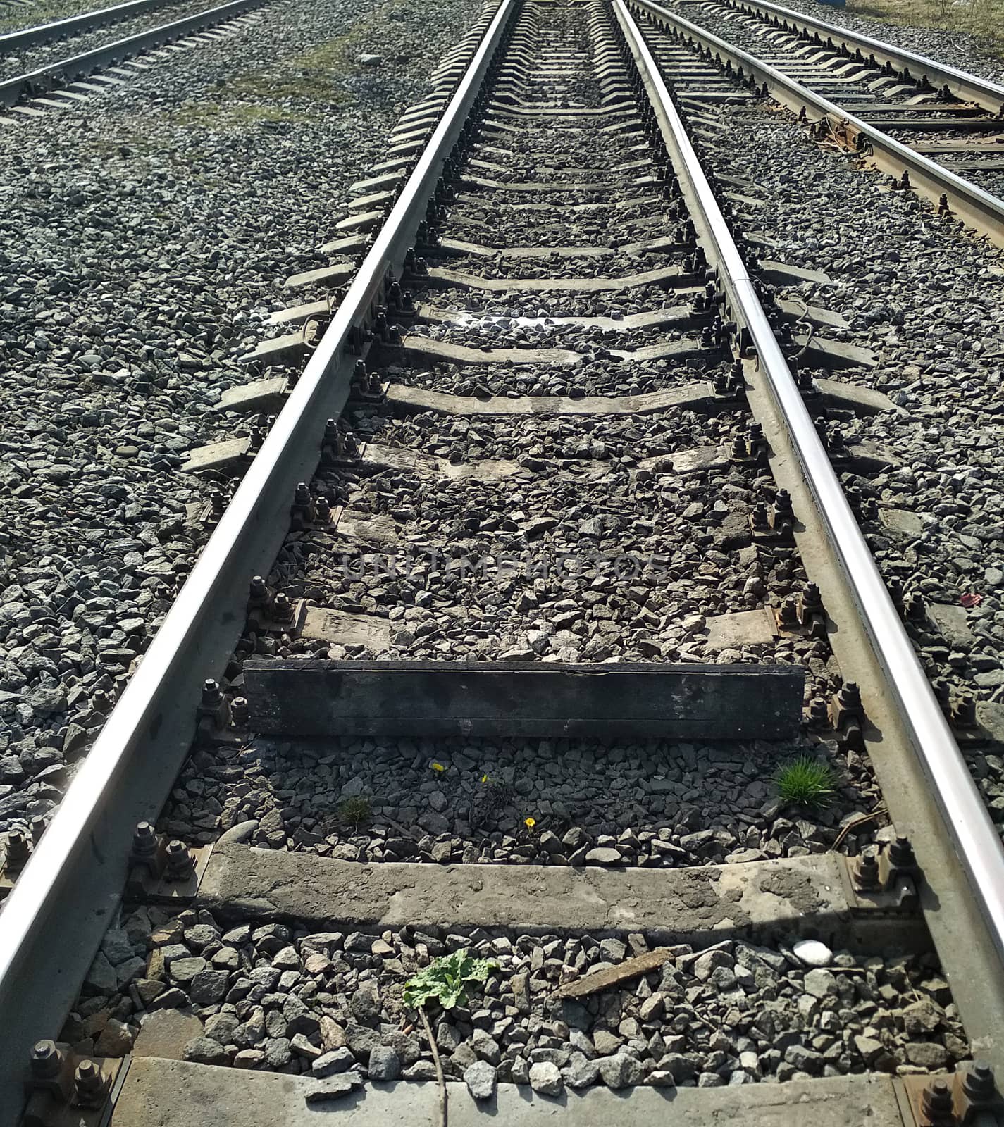 The rails on the sleepers stretching to the horizon on a granite rubble.
