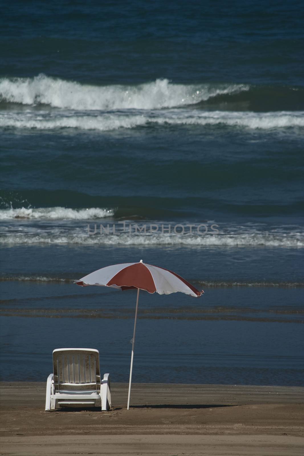 Umbrella and sunbed at the beach landscape with a great blue sky