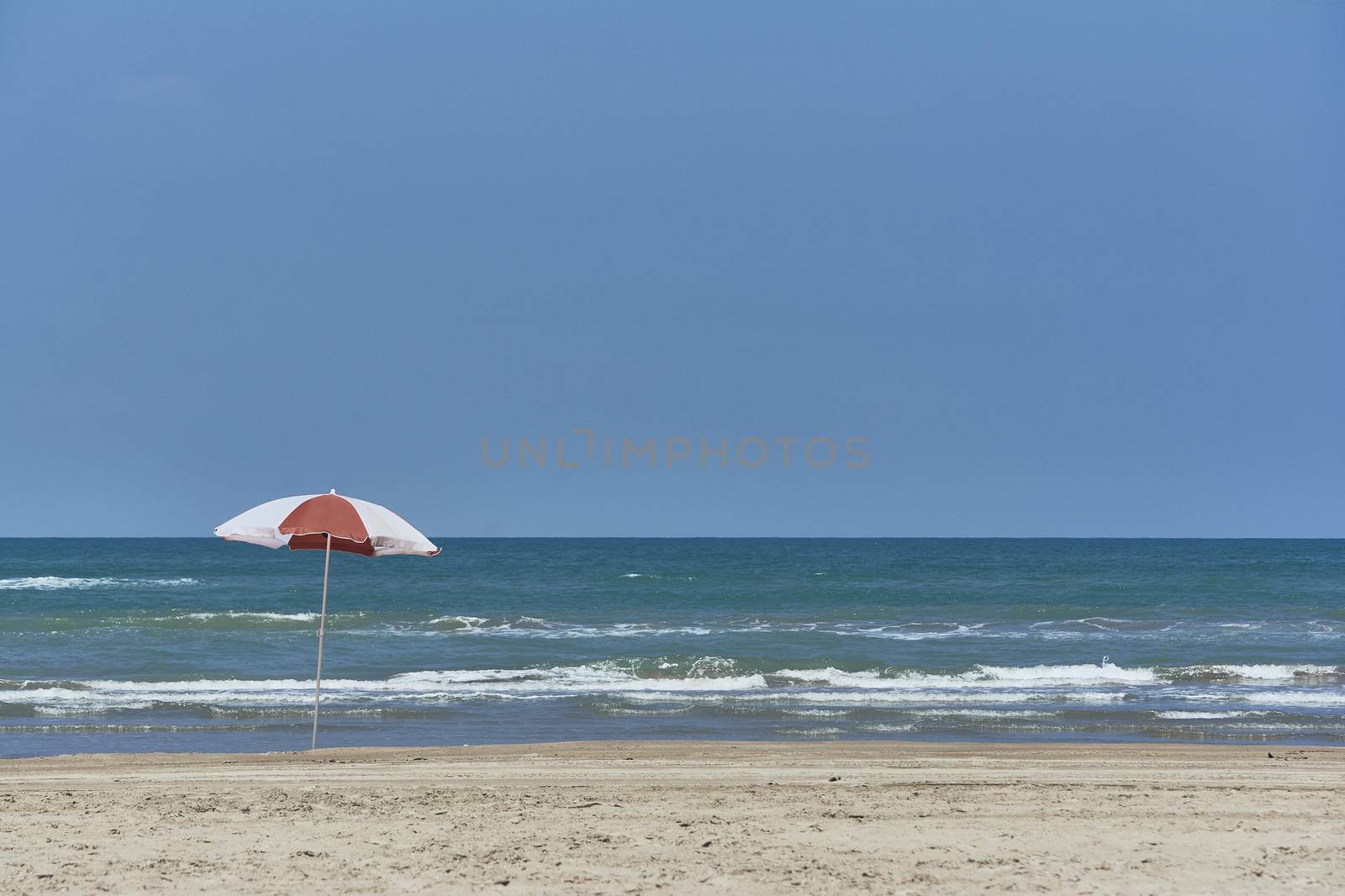 Umbrella and sunbed at the beach landscape with a great blue sky