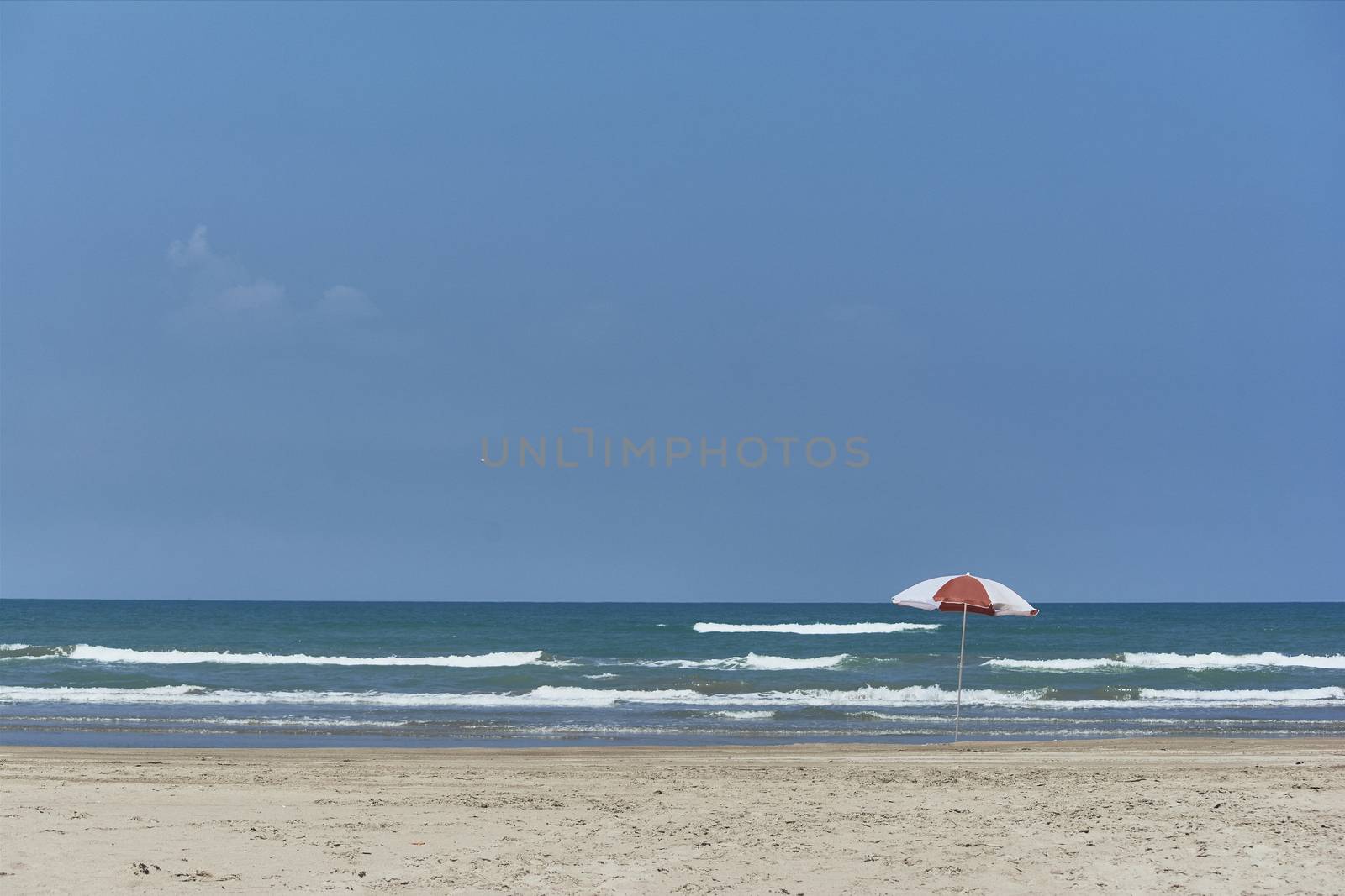 Umbrella and sunbed at the beach landscape with a great blue sky