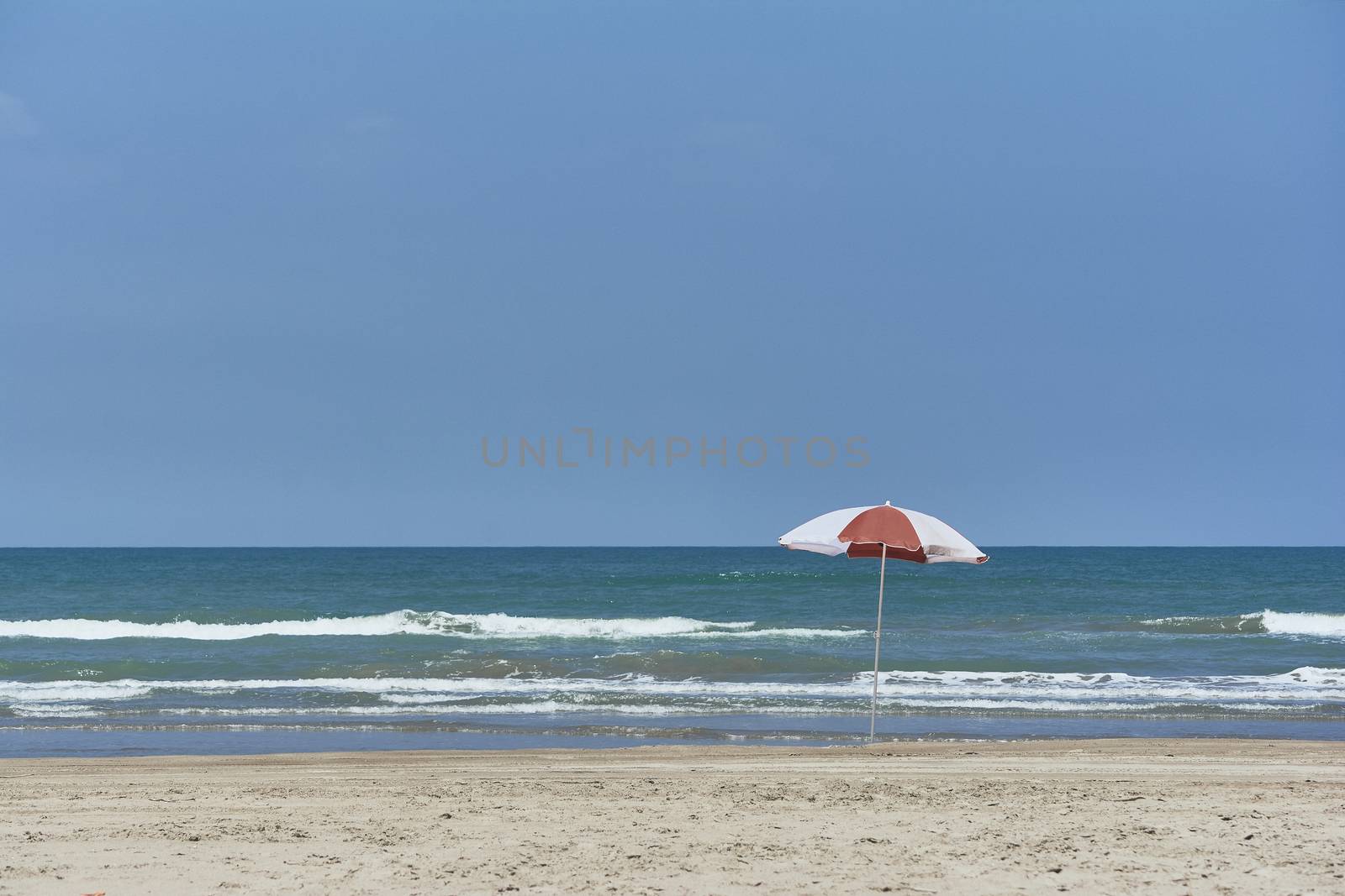 Umbrella and sunbed at the beach landscape with a great blue sky