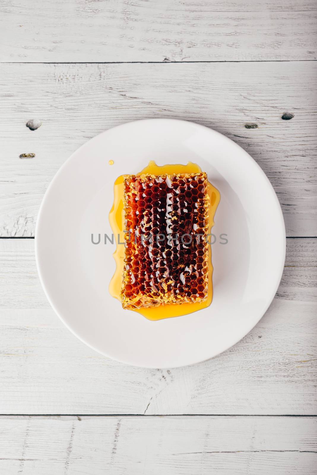 Honeycomb on white plate by Seva_blsv
