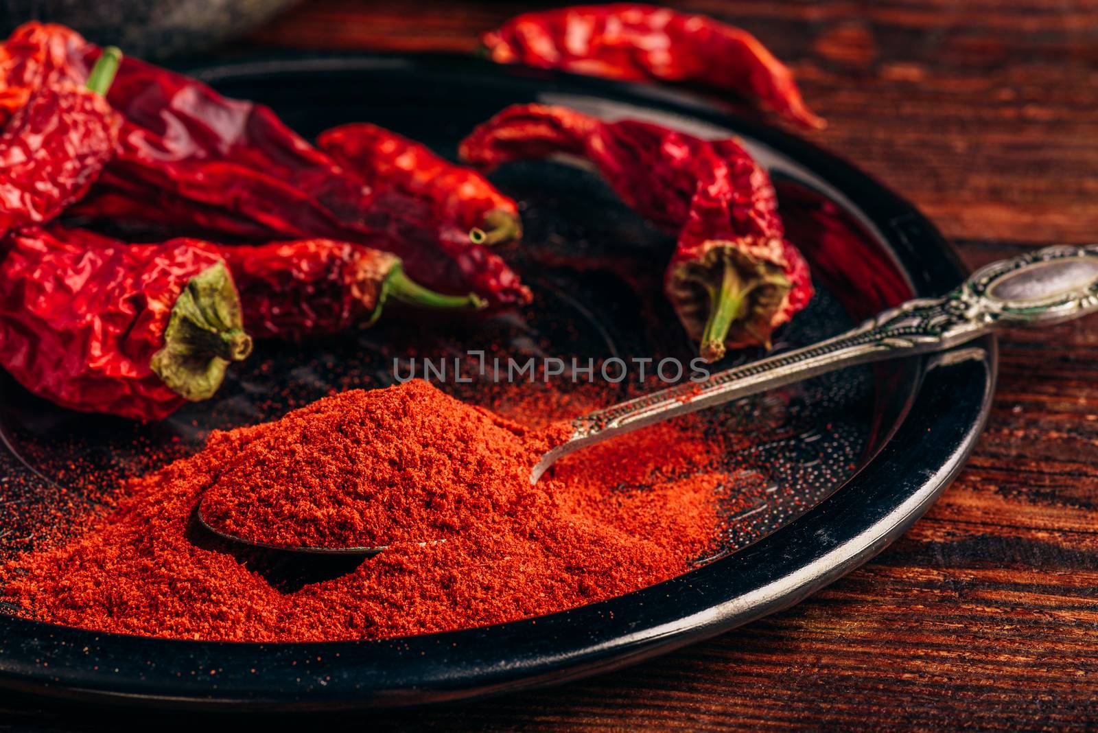 Ground and dried red chili peppers on metal tray