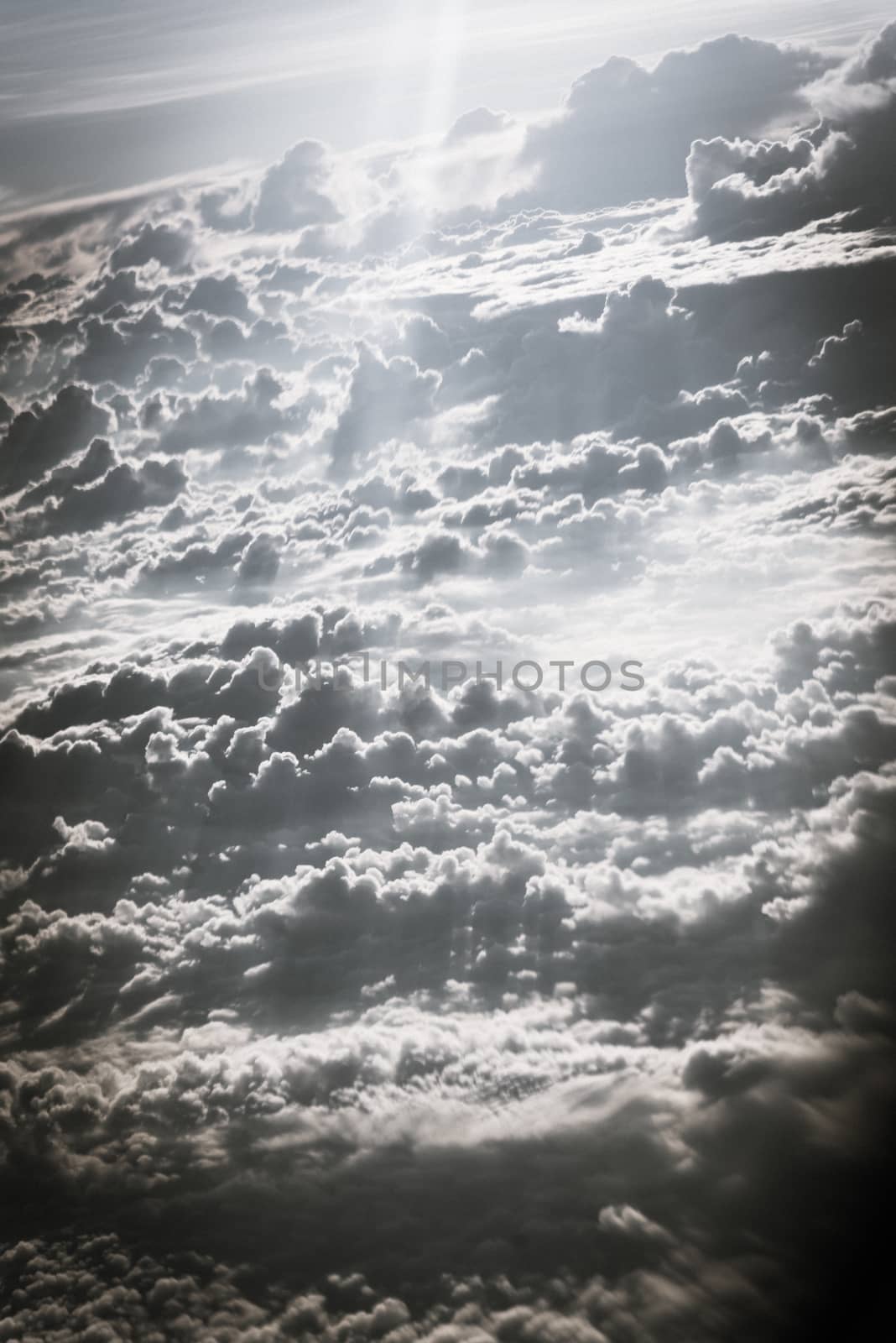 Vintage tone beautiful and unusual Altocumulus or Cirrocumulus cloud formation seen from airplane window at sunrise. Skyline view above the clouds from the air