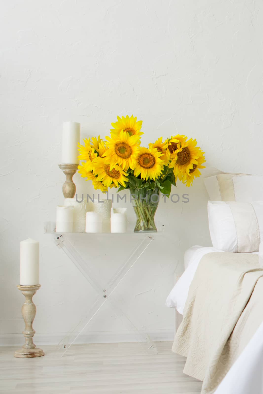 sunflower flowers on the table in a vase in the interior of a bright room by alexandr_sorokin