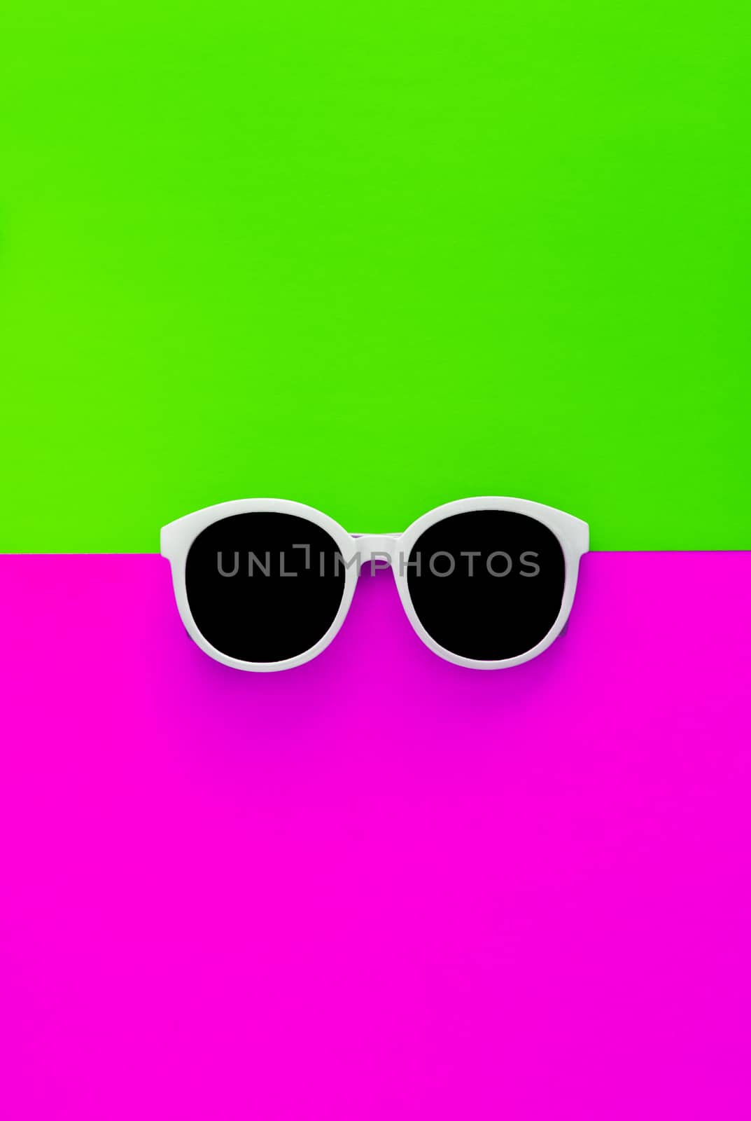 Sunny stylish white sunglasses on a bright green-cyan and crimson-pink background, top view, isolated. Copy space. Flat lay by Tanacha