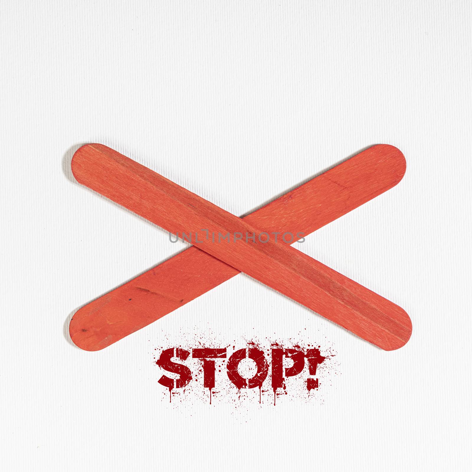 the word Stop under an X of red wood on a white surface