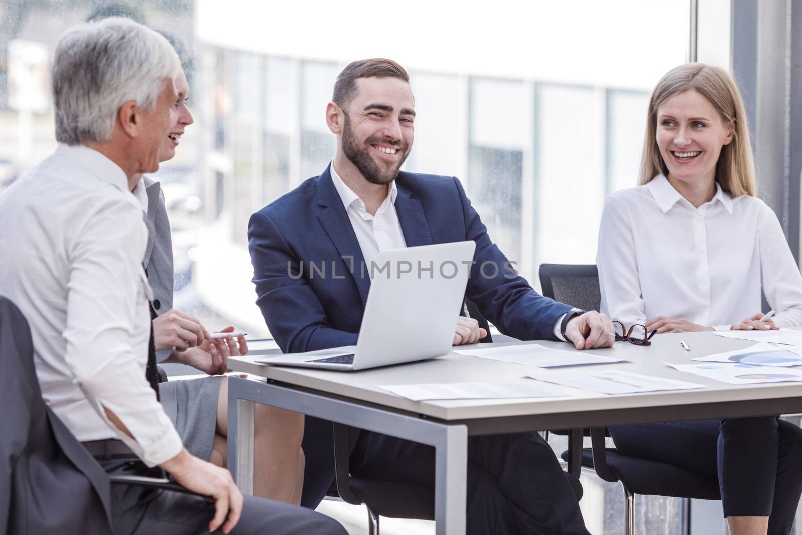Business people laughing at workplace by ALotOfPeople