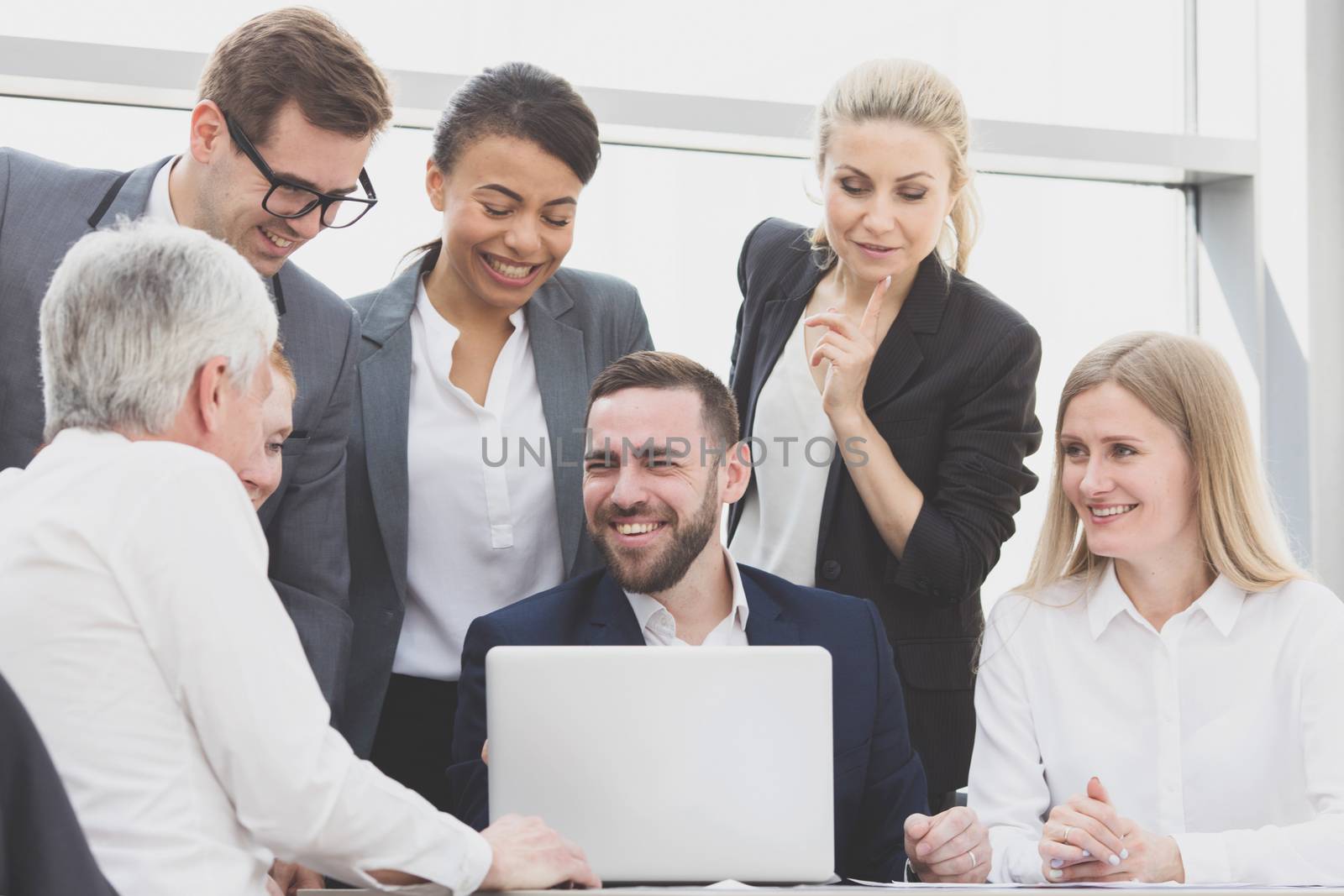 Business team sitting by the table with laptop and documents in office