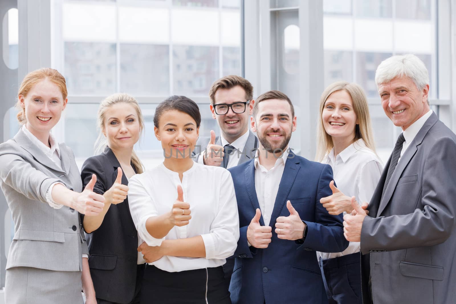 Portrait business people team showing thumbs up , office staff standing in lobby