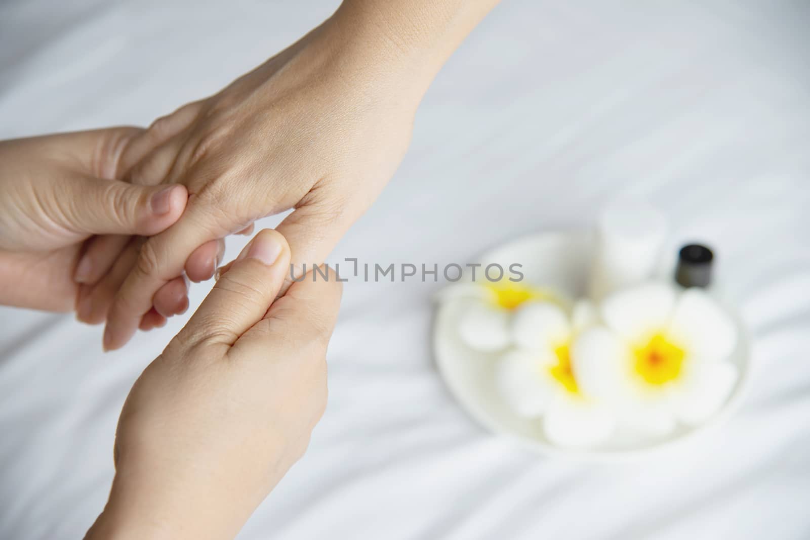 Hand spa massage over clean white bed background - people relax with hand massage service by pairhandmade