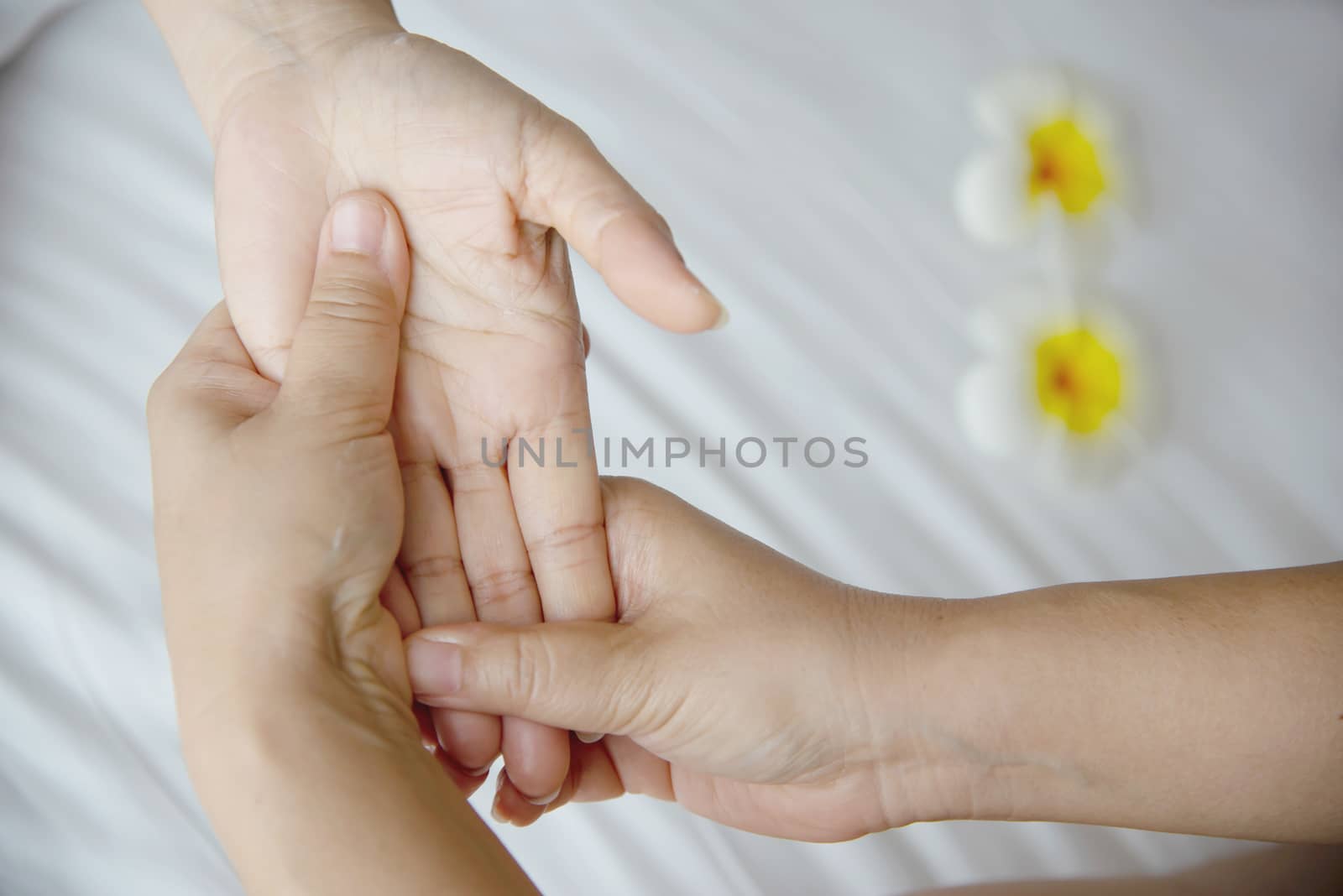 Hand spa massage over clean white bed background - people relax with hand massage service by pairhandmade