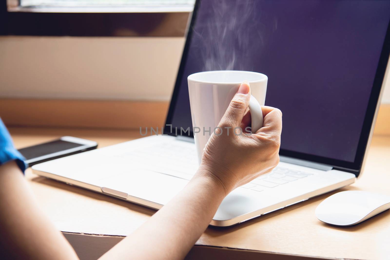 Woman working with computer with coffee cup in the hotel room - people working lifestyle concept