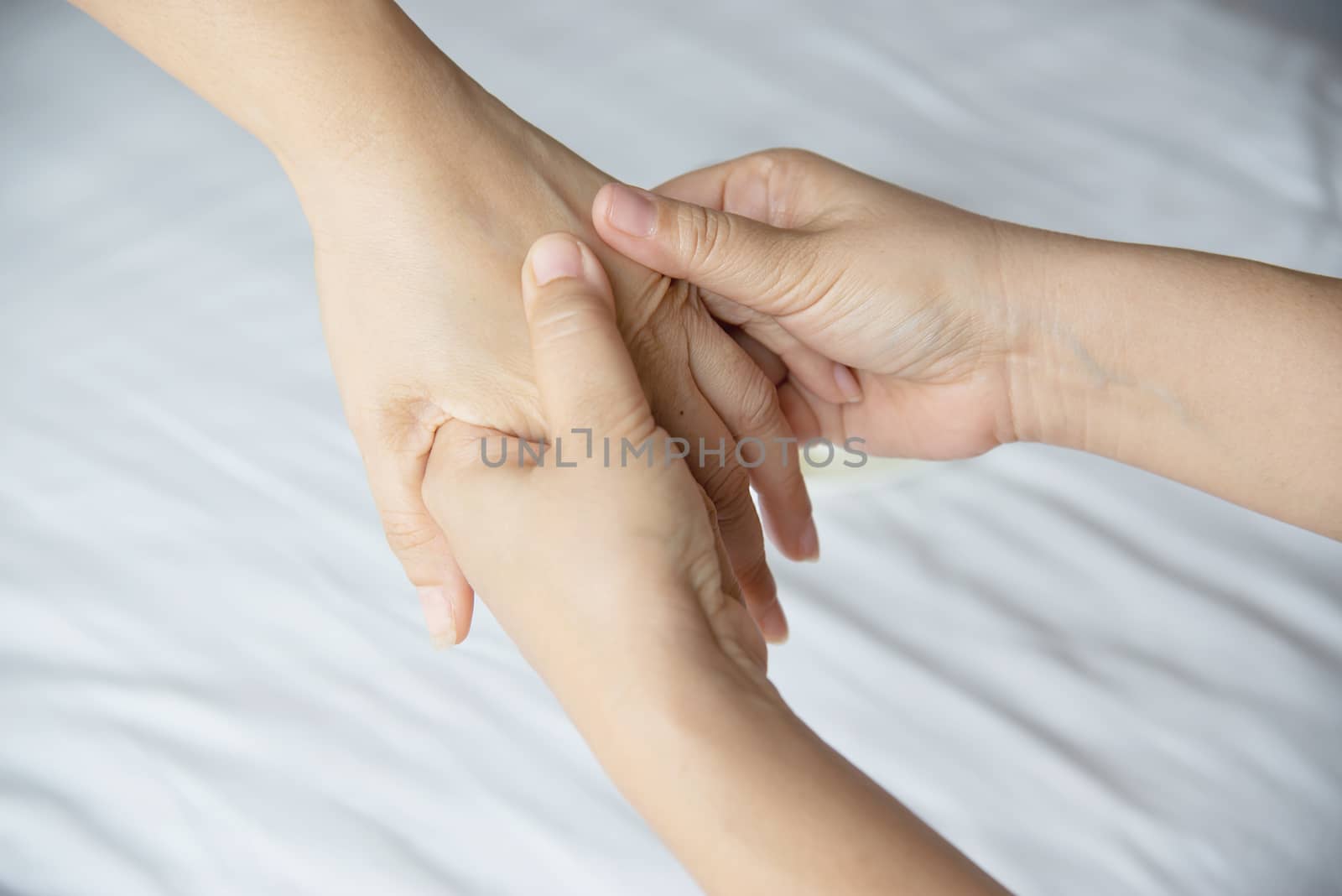 Hand spa massage over clean white bed background - people relax with hand massage service by pairhandmade