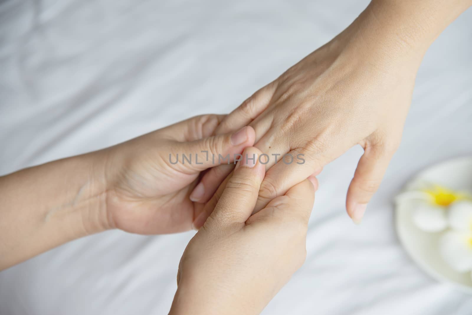 Hand spa massage over clean white bed background - people relax with hand massage service