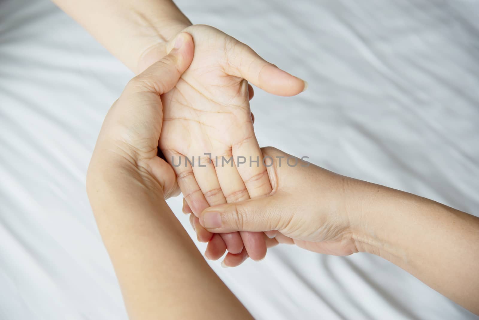 Hand spa massage over clean white bed background - people relax with hand massage service