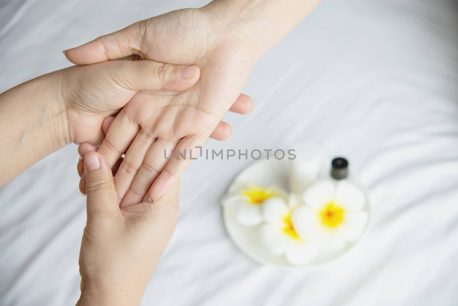Hand spa massage over clean white bed background - people relax with hand massage service