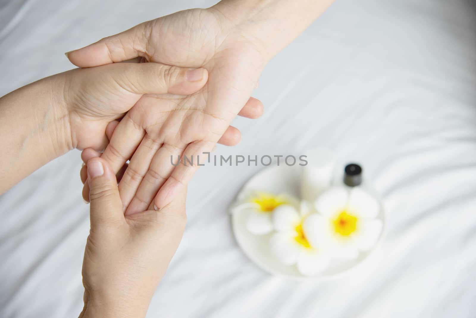 Hand spa massage over clean white bed background - people relax with hand massage service by pairhandmade